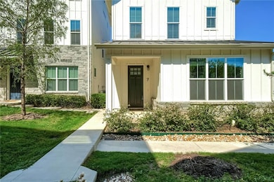 Doorway to property featuring board and batten siding, a standing seam roof, a metal roof, and stone siding