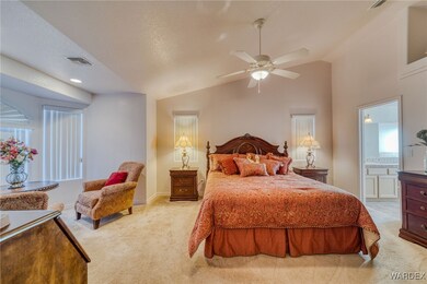 Bedroom with light carpet, ensuite bathroom, and l