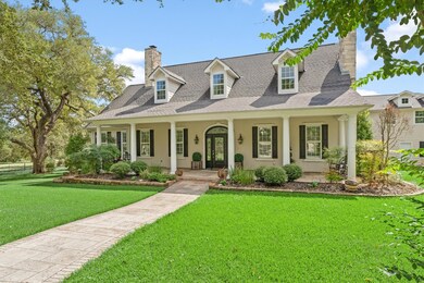 Cape cod house with a chimney, a front yard, stuc