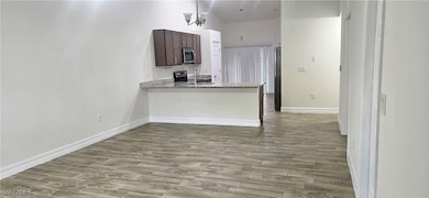 Kitchen with stainless steel microwave, wood finis