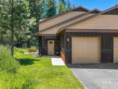 View of front of house with board and batten siding, a garage, a front lawn, and driveway