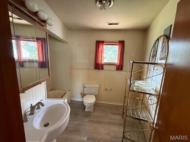 Bathroom with a wainscoted wall and light wood-type flooring
