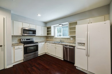 Kitchen with stainless appliances, refrigerator and pantry.
