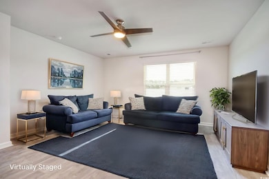 Living area featuring light wood-style flooring and ceiling fan