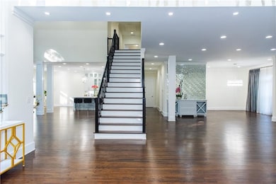 Stairway featuring wood finished floors, recessed lighting, and decorative columns