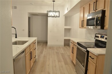 Kitchen featuring light stone countertops, stainle