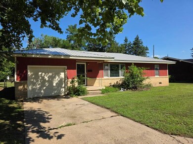 Single story home featuring an attached garage, driveway, brick siding, and a front lawn