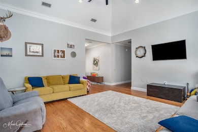 Living room with crown molding, lofted ceiling, an