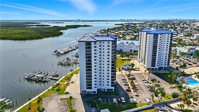 Aerial view of condominium buildings, a nearby body of water and numerous boat docks - Virtually Edited Image