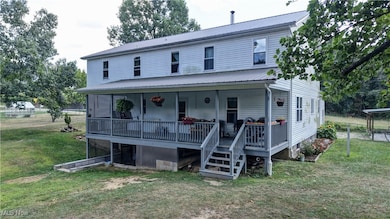 View of back of property featuring a porch, back yard, and a metal roof