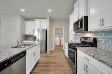 The Utility room is right off the kitchen and has a door leading into the garage.