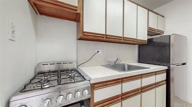 Kitchen with appliances with stainless steel finishes, light countertops, and white cabinetry