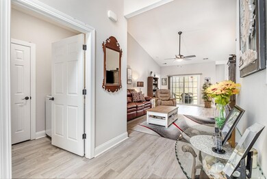 Living area featuring lofted ceiling, baseboards, 