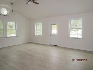 LIVING AREA SHOWING FRONT ENTRANCE DOOR.