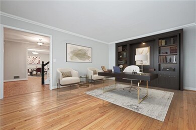 Home office featuring crown molding, light wood-style flooring, and built in features