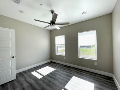 Empty room with dark wood-style flooring, a ceiling fan, and recessed lighting