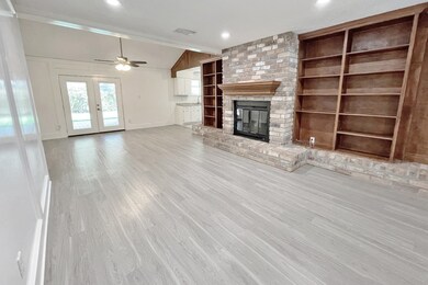 Living Room with brick fire place and built in shelves.