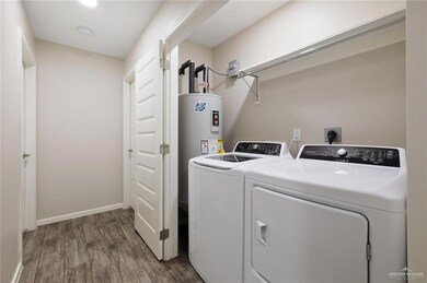 Washroom featuring separate washer and dryer, wood finished floors, and baseboards