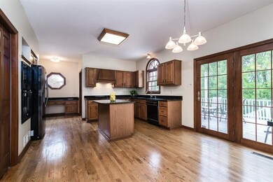 Large kitchen with hardwood flooring and granite c