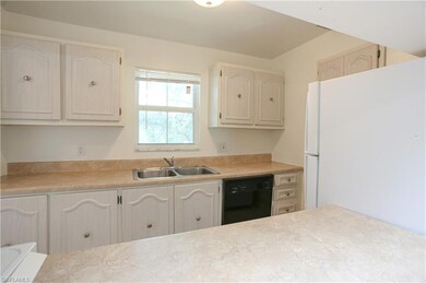 Kitchen featuring sink, white refrigerator, and di