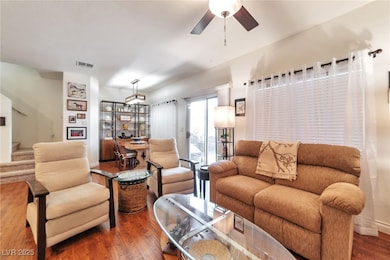 Living area featuring wood finished floors, a ceiling fan