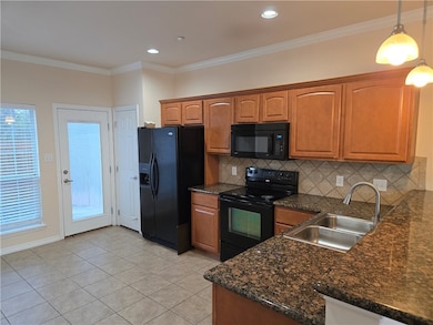 Kitchen with backsplash, black appliances, crown m
