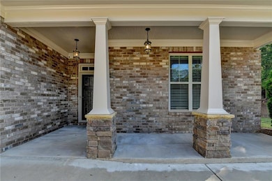 Entrance to property with brick siding and a porch