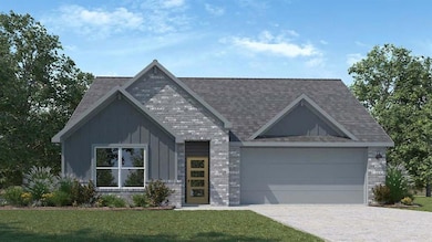 View of front of house featuring decorative driveway, a front yard, a garage, and brick siding