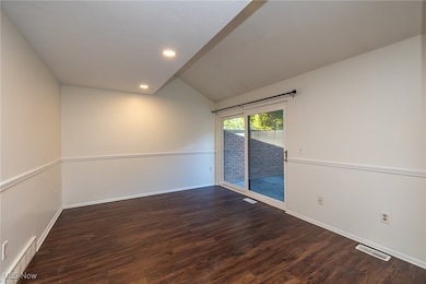 Unfurnished room with lofted ceiling, dark wood-style floors, and recessed lighting