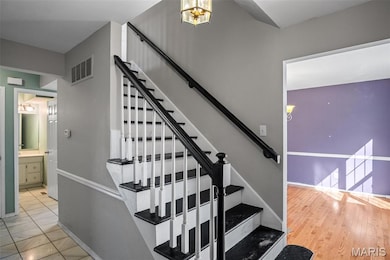 Staircase featuring a chandelier and baseboards