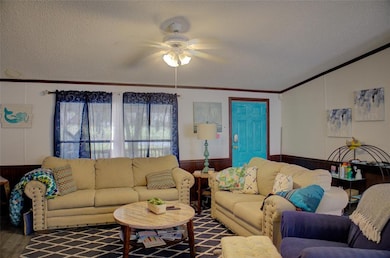 Living area featuring a textured ceiling, a wainsc
