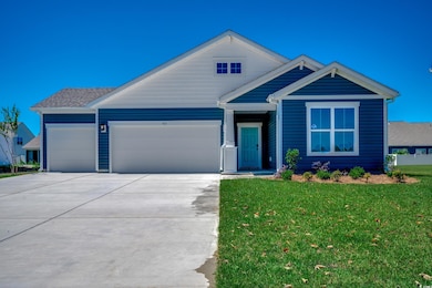 View of front of house with concrete driveway, a garage, and a front yard