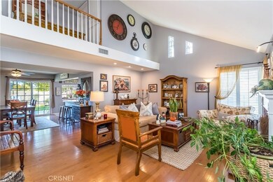 Enter into a lovely living room with wood floors, gas fireplace, vaulted ceilings, wood shutters & many more lovely details
