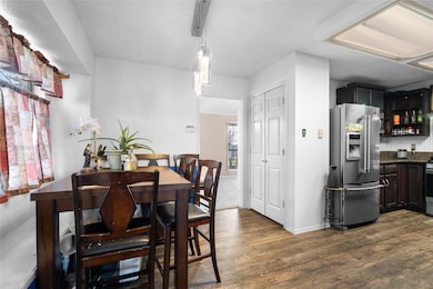 Dining room with dark wood-type flooring and baseboards