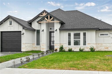 View of front of home with a garage and a front lawn