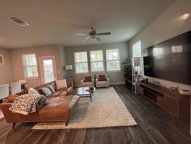 Living room with dark wood finished floors, ceili
