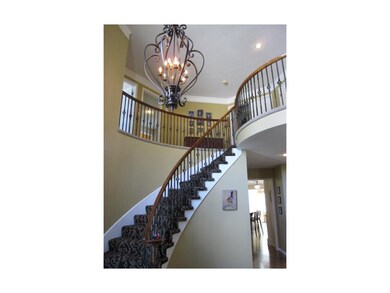 Elegant Curved Staircase With Wrought Iron Spindle