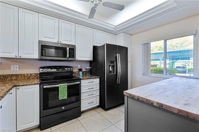 Kitchen with ceiling fan, light tile patterned flo