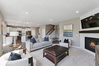 (Photo of decorated model, colors and features will vary) A view across the main level - defined spaces but open and filled with natural light. The LVP flooring will continue into the great room and a centered stone fireplace is included.