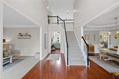 Entryway with stairs, wood finished floors, a chandelier, baseboards, and a high ceiling