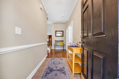 Corridor with crown molding, visible vents, stairw