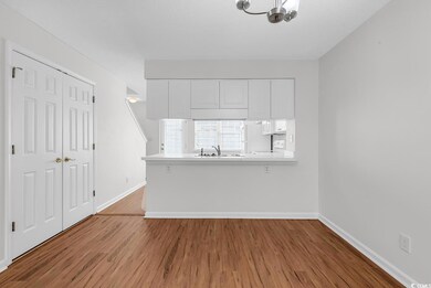 Interior space with an inviting chandelier, wood finished floors, baseboards, and a sink