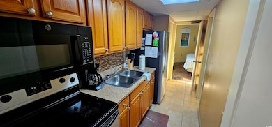 Kitchen featuring tasteful backsplash, light tile 