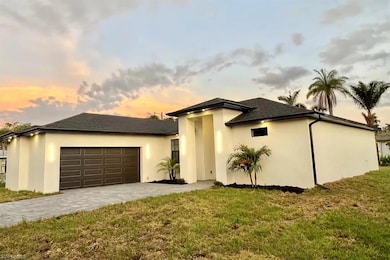 View of front of home with an attached garage, decorative driveway, stucco siding, and a front yard