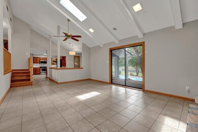 Unfurnished living room with ceiling fan, beamed c