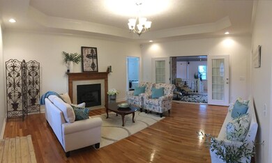 Lovely Living room with Trey ceiling, New light fixture, hardwood floors, fireplace & mantle, fresh neutral paint,  French doors into Florida room