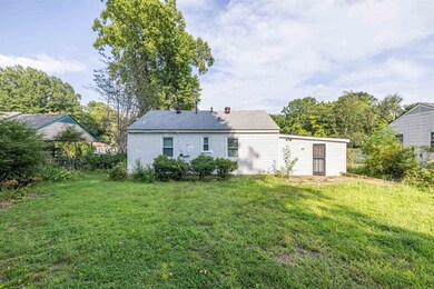Rear view of property with a yard