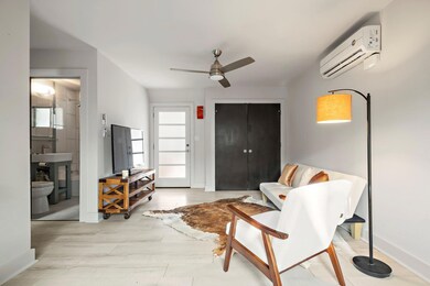 Sitting room with baseboards, a wall mounted AC, 