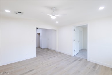 Unfurnished room with a ceiling fan, light wood-st