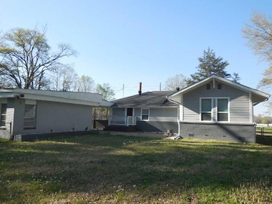 Rear view of property featuring crawl space, brick